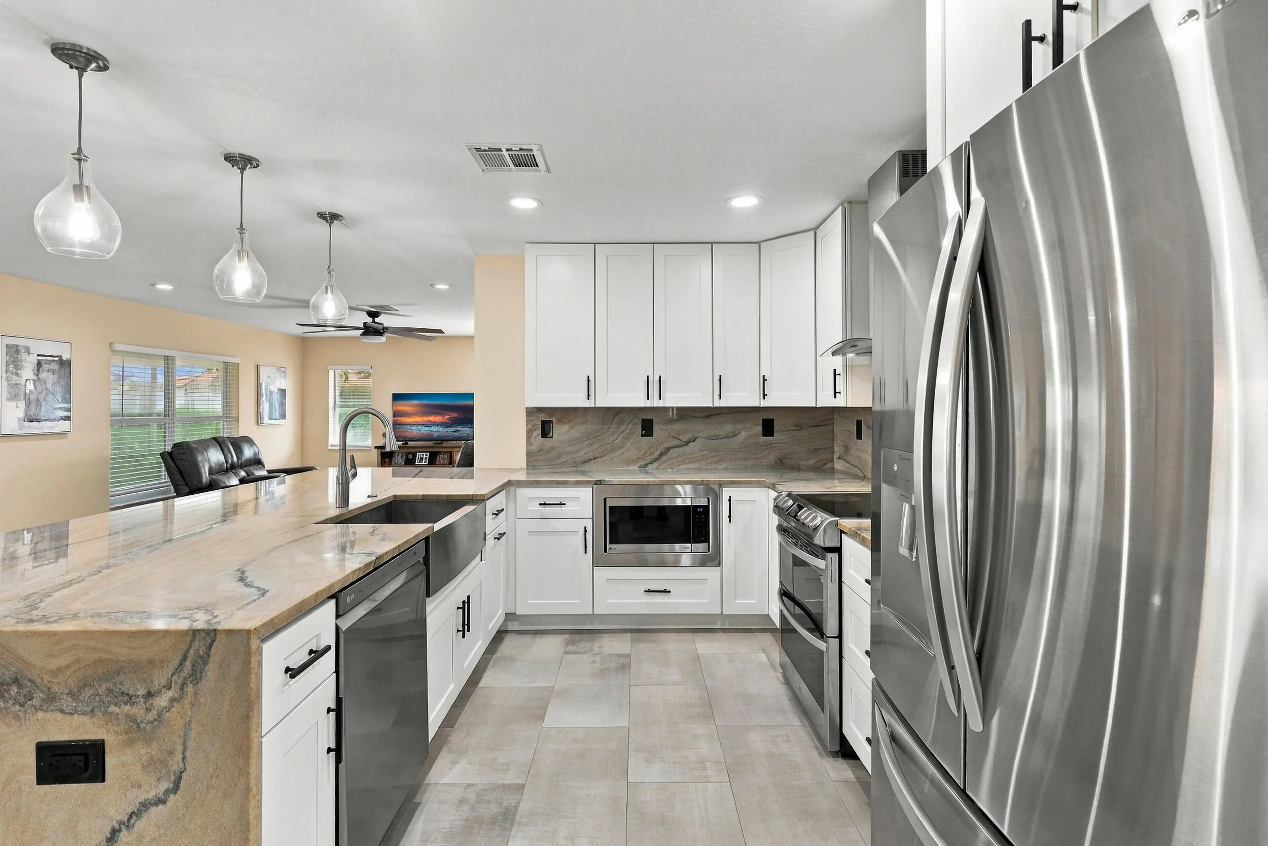 The heart of the home is the exquisite renovated kitchen, featuring white Shaker style cabinetry, stunning quartzite countertops and backsplash, stainless steel appliances, designer lighting, abundant storage, and an oversized island that creates an impressive centerpiece for everyday living and entertaining. The open layout flows effortlessly into the main living areas and breakfast nook, while a separate dining space provides plenty of room for gatherings.