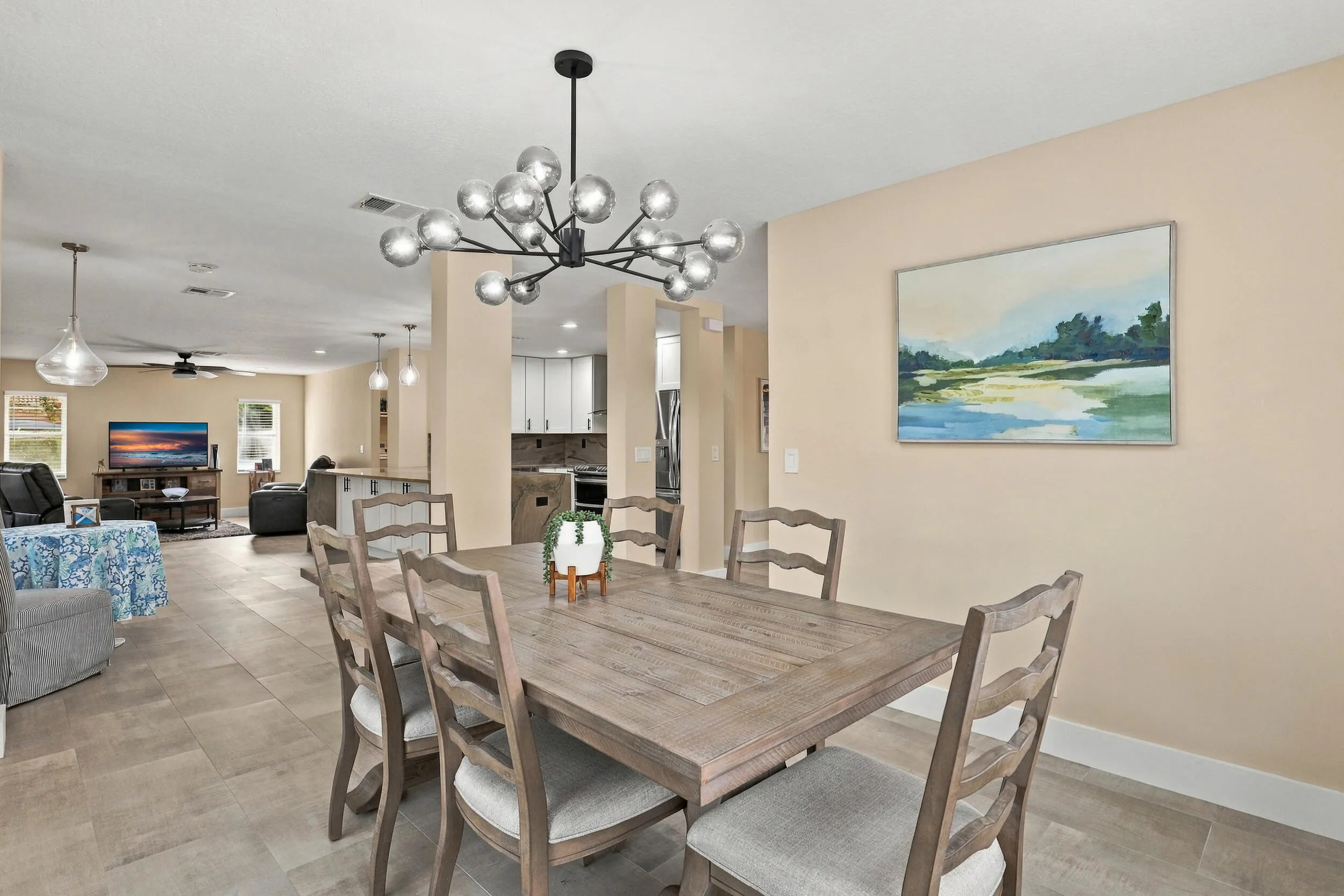 The formal dining room is wrapped in an abundance of light from two oversized windows and highlighted by a designer chandelier.