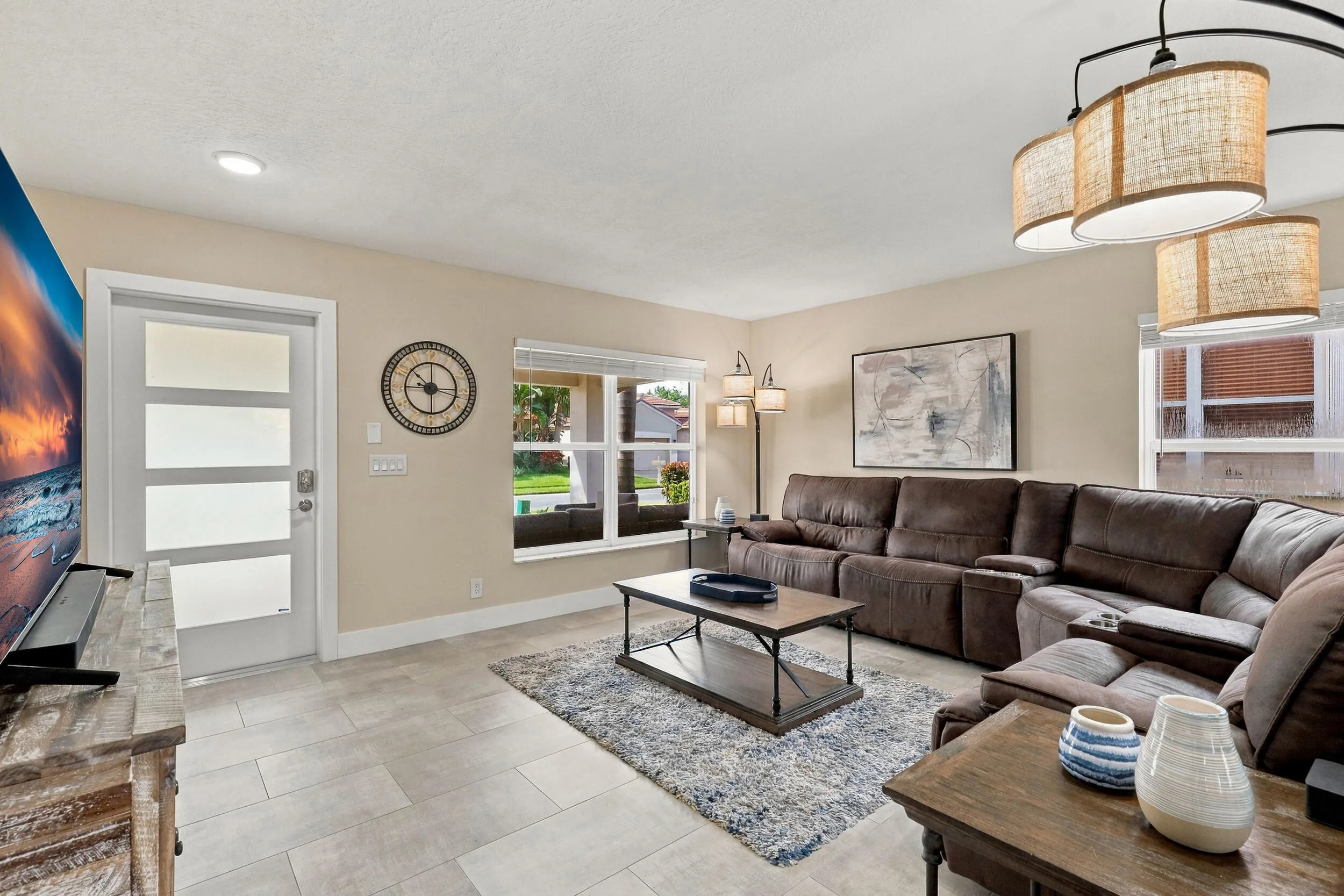The formal living room is filled with an abundance of light, new window treatments, and is highlighted by the brand-new porcelain tile floors.