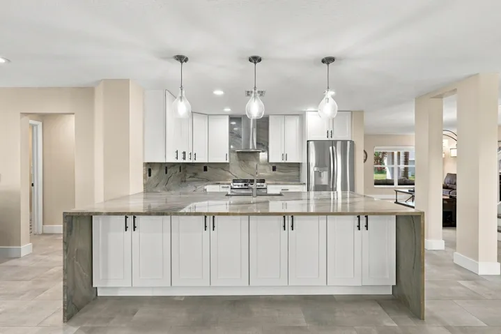 The enormous kitchen peninsula provides tons of additional storage, a great place to gather and eat within the kitchen, and is highlighted by a magnificent piece of natural quartzite stone.