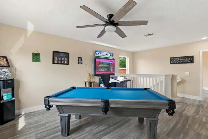 Upstairs is an entertainer's dream. The loft space (which could be a fifth bedroom) is currently a game room with a pool table, arcade games, and is a great space to relax and unwind. This home is being sold fully furnished!