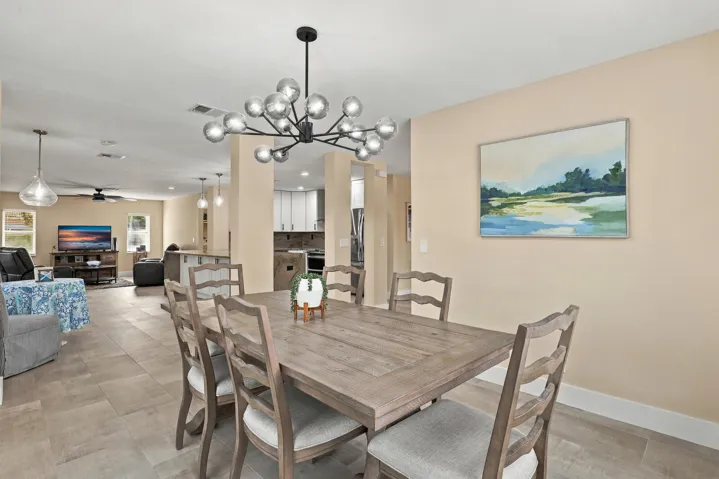 The formal dining room is wrapped in an abundance of light from two oversized windows and highlighted by a designer chandelier.