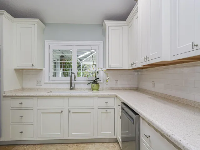 White shaker-style cabinetry, light-granite subway tile backsplash.