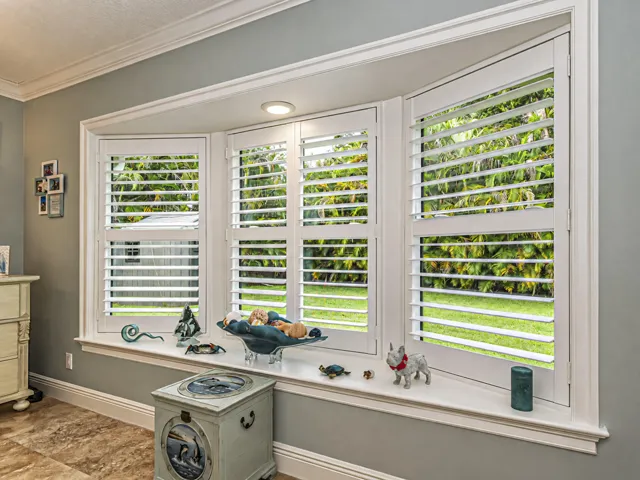 Bay window with white plantation shutters and crown molding