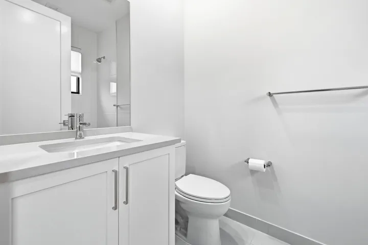 White vanity with an integrated sink, polished chrome faucet, and coordinating hardware