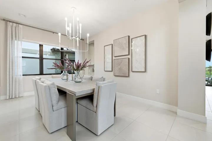 Recessed lighting, large window with dark trim, light-toned wall paint, contemporary chandelier, and light-toned tile flooring