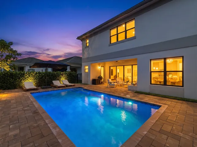 Rectangular swimming pool surrounded by a paver patio