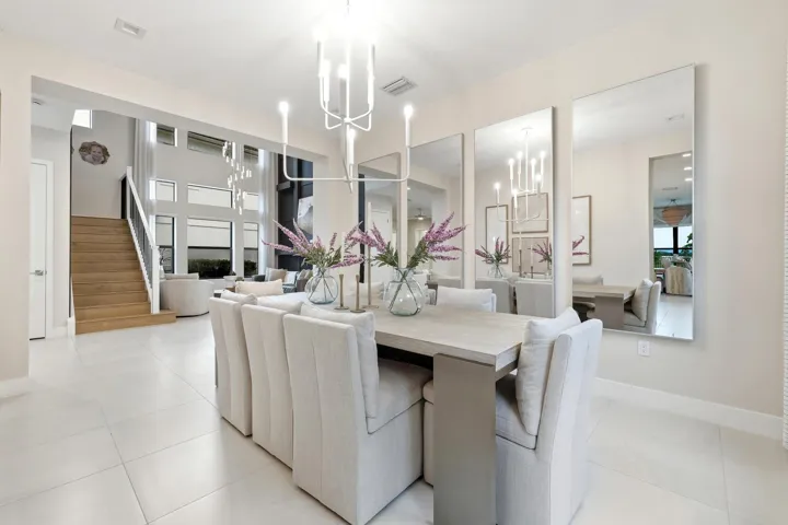 Open-concept dining area featuring a light-toned dining table and white tile flooring