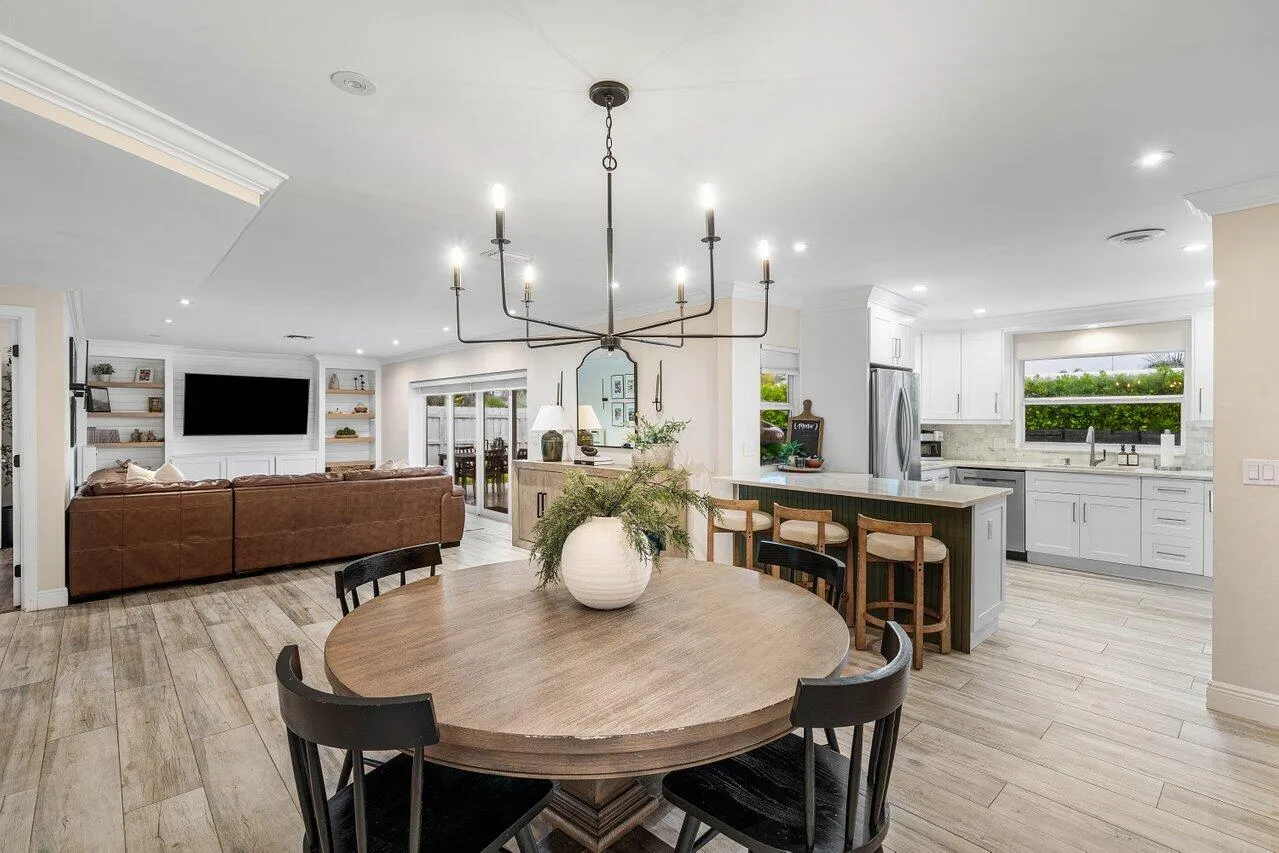 A chandelier anchors the dining area, with the kitchen and living room close by.