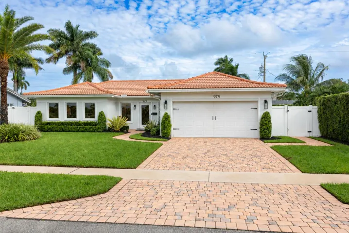 Paver driveway and landscaped front lawn.