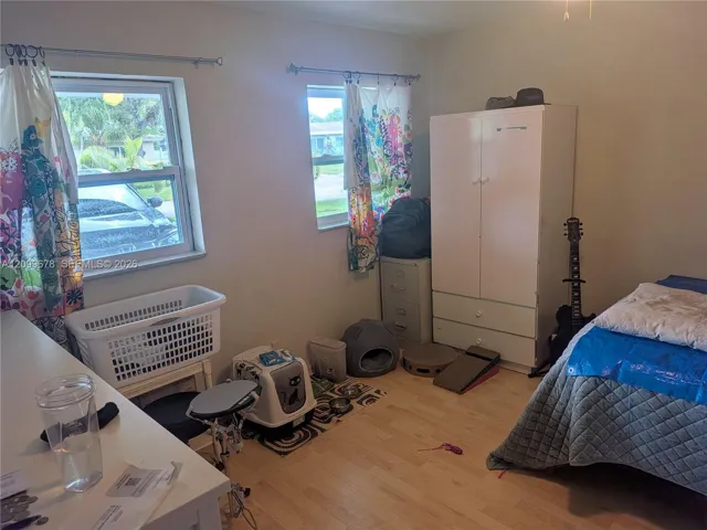 Interior space featuring wood-finish flooring and two windows with metal hardware