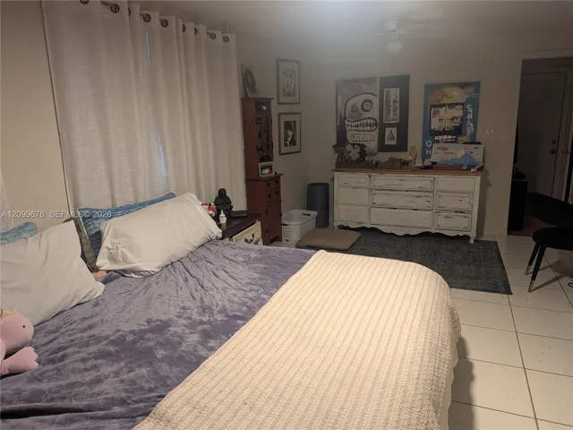 Large-format neutral floor tiling and ceiling-mounted light fixture with integrated fan