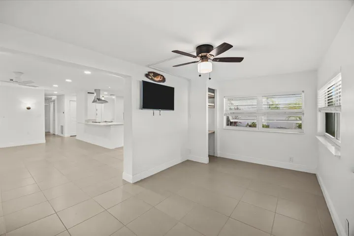 Recessed lighting, ceiling fan, tile flooring, built-in shelving, and white walls