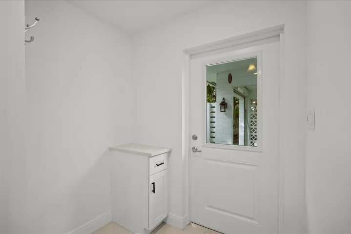 White entry door with a clear glass insert and brushed nickel hardware