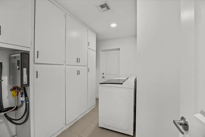 Extensive built-in white cabinetry, tiled flooring, recessed lighting, and a tankless water heater