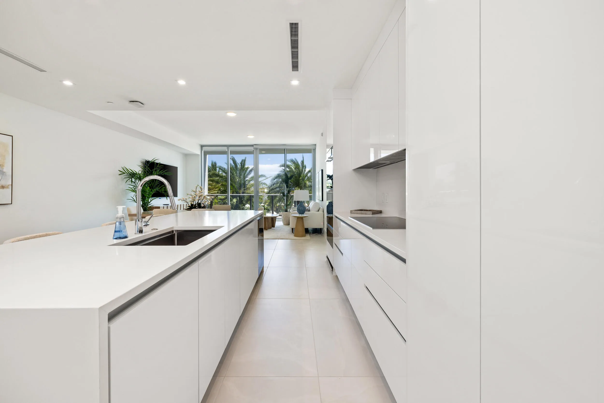 Gourmet kitchen featuring a waterfall island, integrated sink, flat-panel cabinetry, and recessed lighting