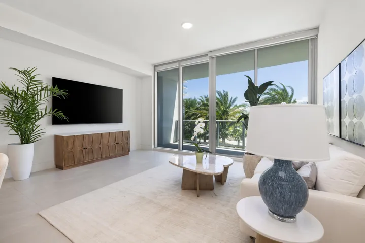 Recessed lighting, large format tile flooring, and floor-to-ceiling sliding glass doors leading to a balcony
