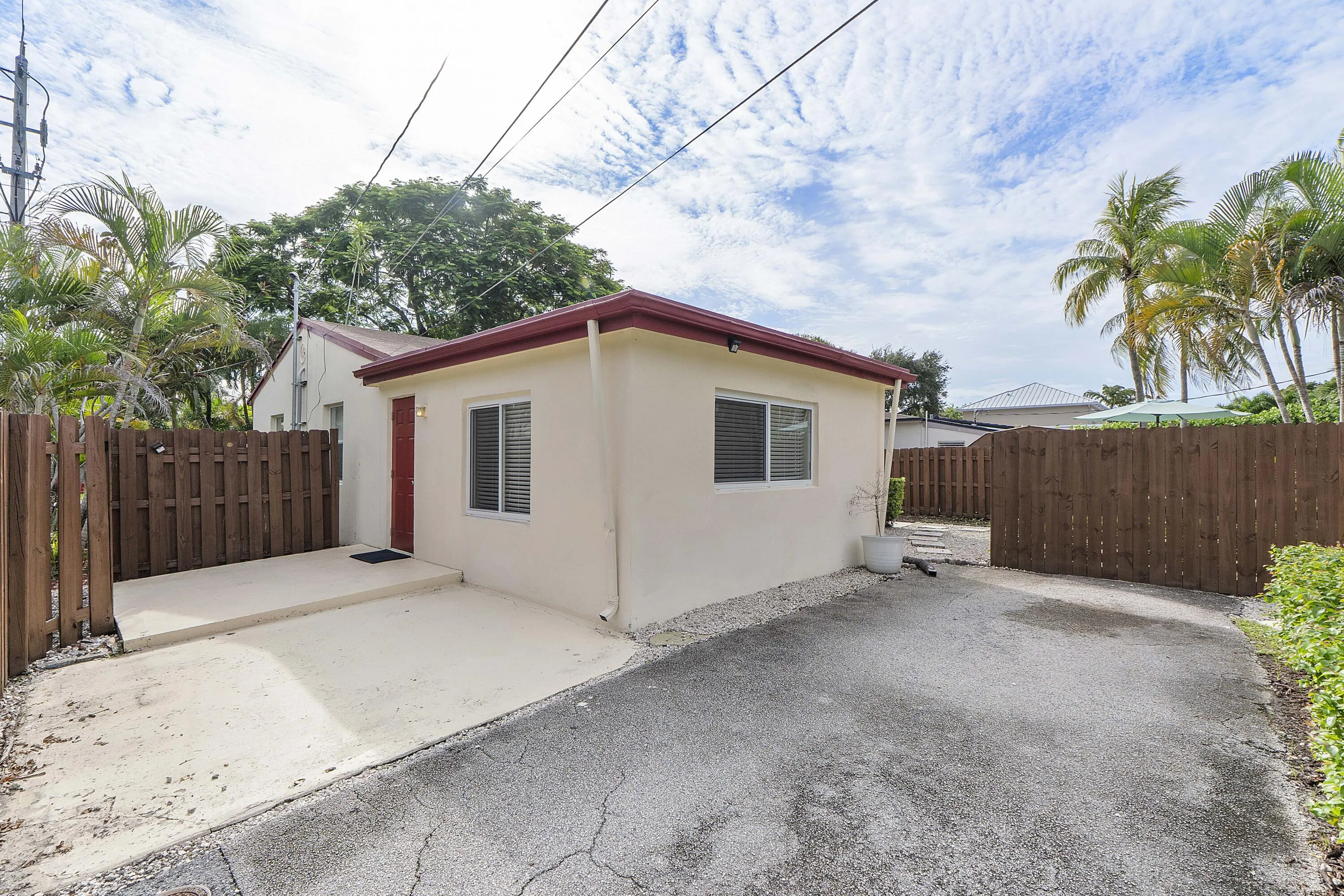 another side and back view with driveway enough for multiple cars. More parking beyond fence