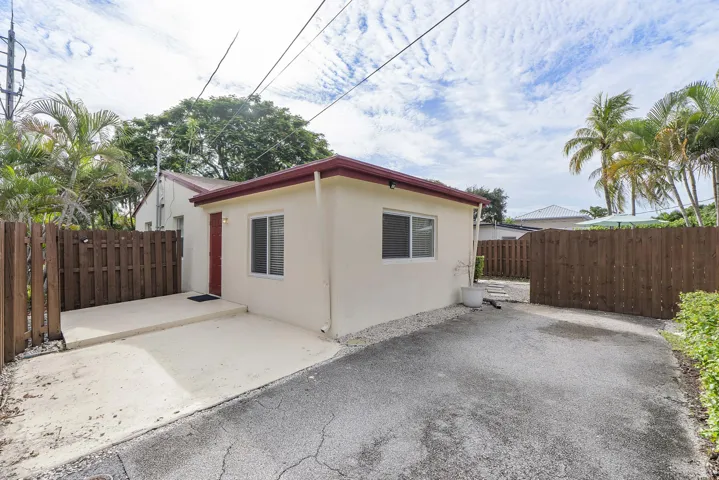 another side and back view with driveway enough for multiple cars. More parking beyond fence