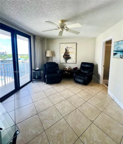 Large glass sliding doors, ceramic tile flooring, and a ceiling-mounted fan