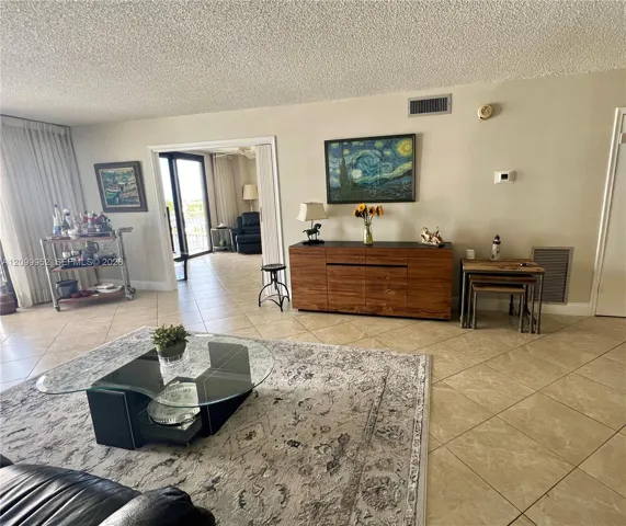 Ceramic tile flooring, sliding glass terrace doors, and textured ceiling finish