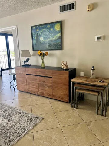 Large format neutral-toned tile flooring and sliding glass door with external access