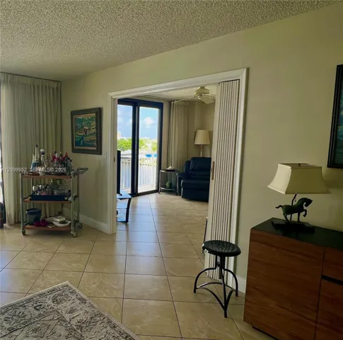 Neutral-toned ceramic tile flooring, floor-to-ceiling glass sliding doors, and white bi-fold accordion doors
