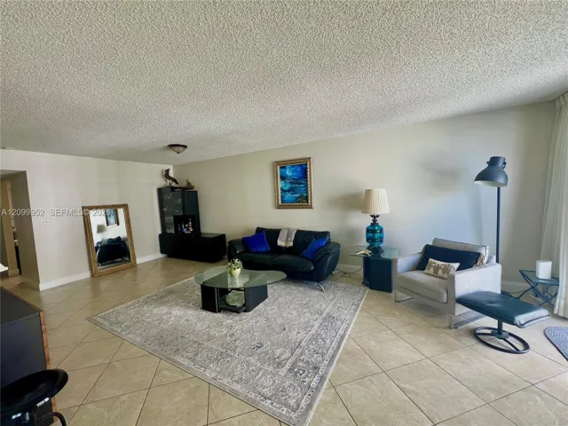 Spacious interior featuring large-format diagonal tile flooring, textured ceiling, and neutral wall tones