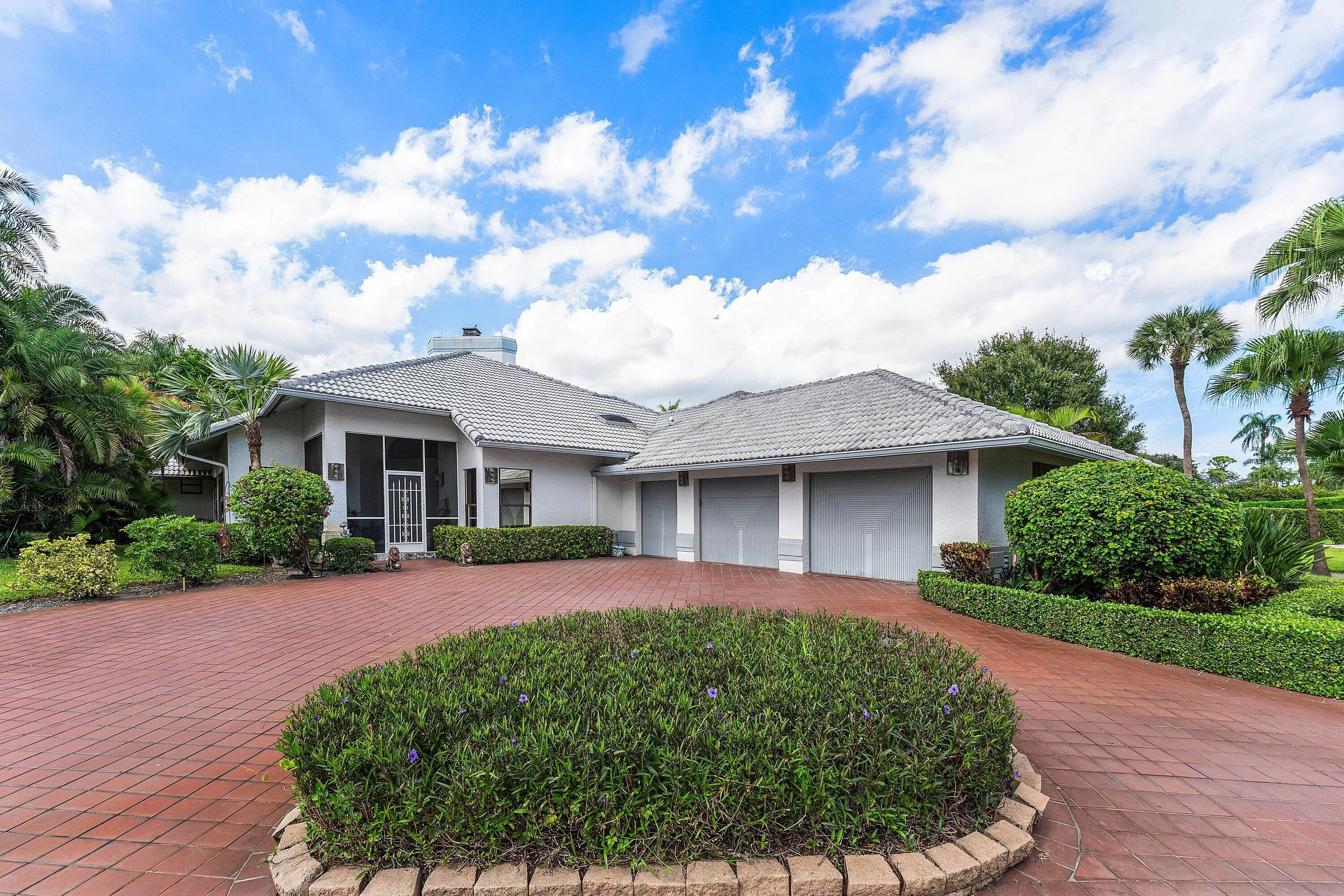 White exterior with a grey tile roof and a screened entry