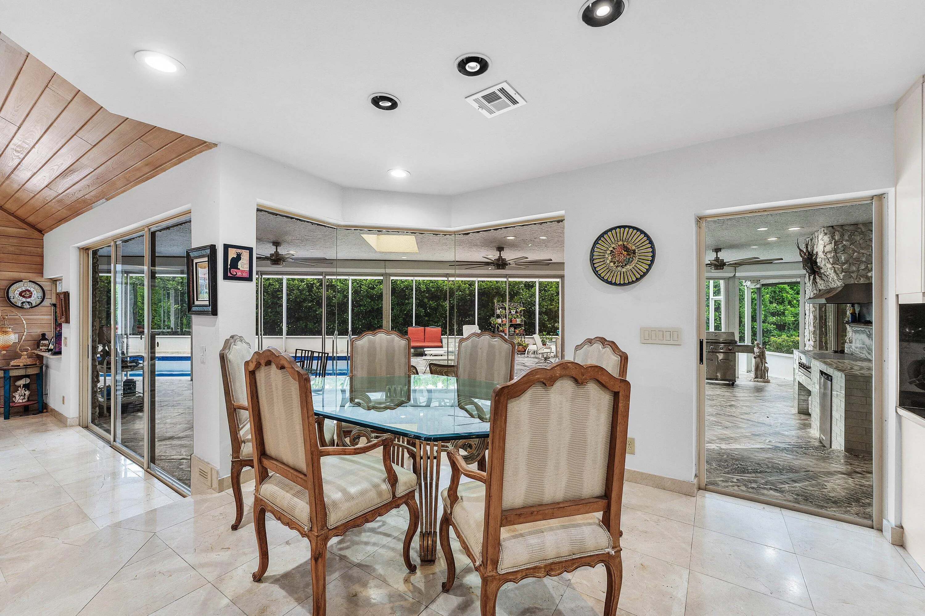 Recessed lighting illuminating the dining space with tile flooring