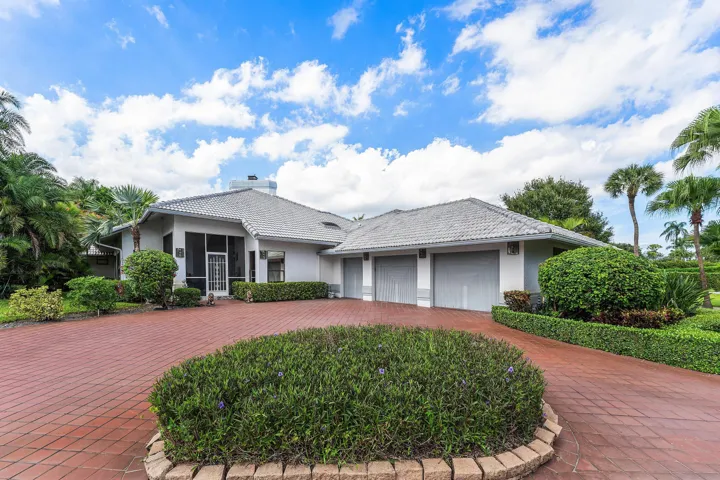 White exterior with a grey tile roof and a screened entry