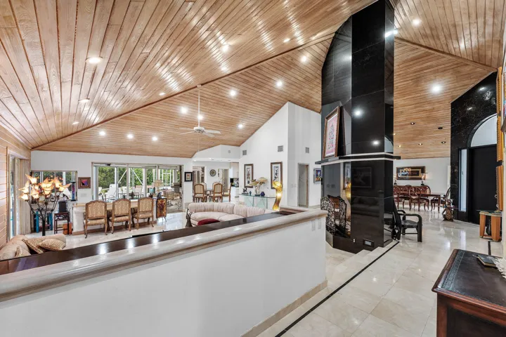 Expansive interior with vaulted wood-finish ceilings, recessed lighting, and tile flooring