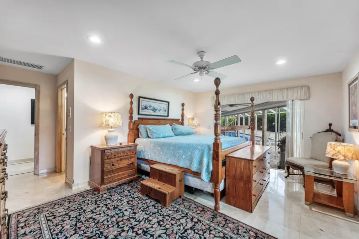 Recessed lighting, ceiling fan, tile flooring, sliding glass door, and a screened enclosure