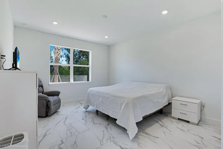 Large primary bedroom with upgraded tile and plenty of natural light