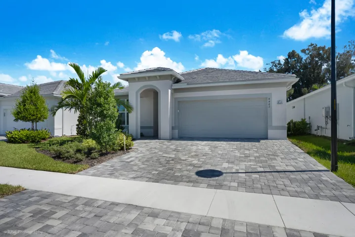 Over-sized paver driveway with lush landscaping creating amazing curb appeal