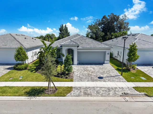 Curb appeal and great energy with an over-sized driveway leading to an extended garage wrapped by lush landscaping