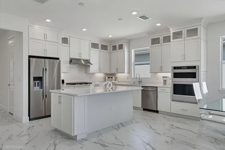 A kitchen that continues to give.... from the wall oven & microwave, upgraded 42" cabinets with additional glass front upper cabinets, under cabinet lighting, large island, and more