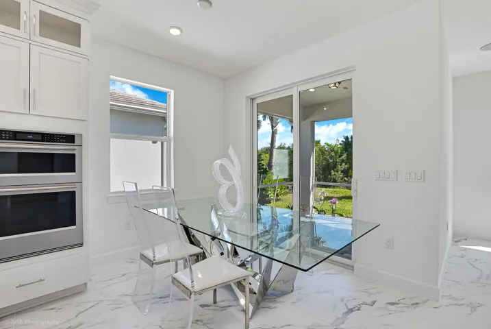 Dining area with over-sized impact sliders leading to a covered screened lanai