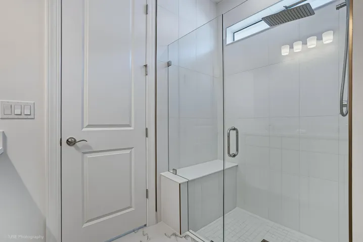 Upgraded shower with seat & frameless shower door in primary bath