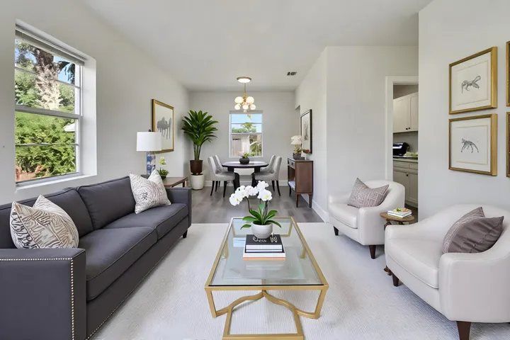 Open-concept living area with light gray walls, wood-finish flooring, and recessed lighting