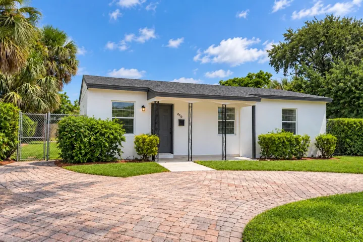 White stucco exterior with a dark shingle roof