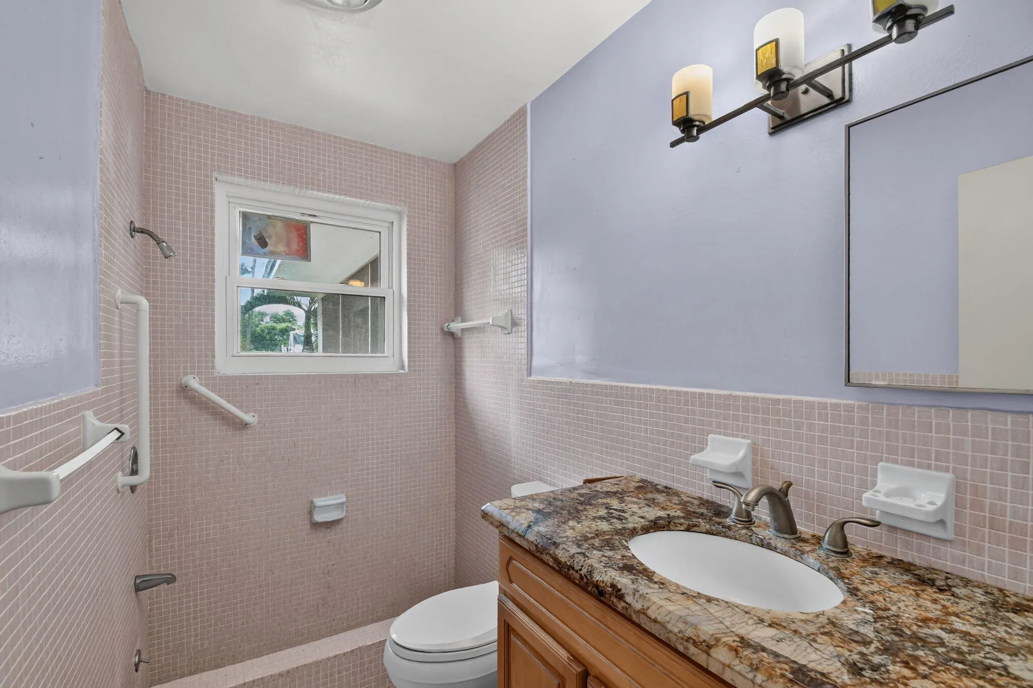 Vanity with granite countertop and oval sink