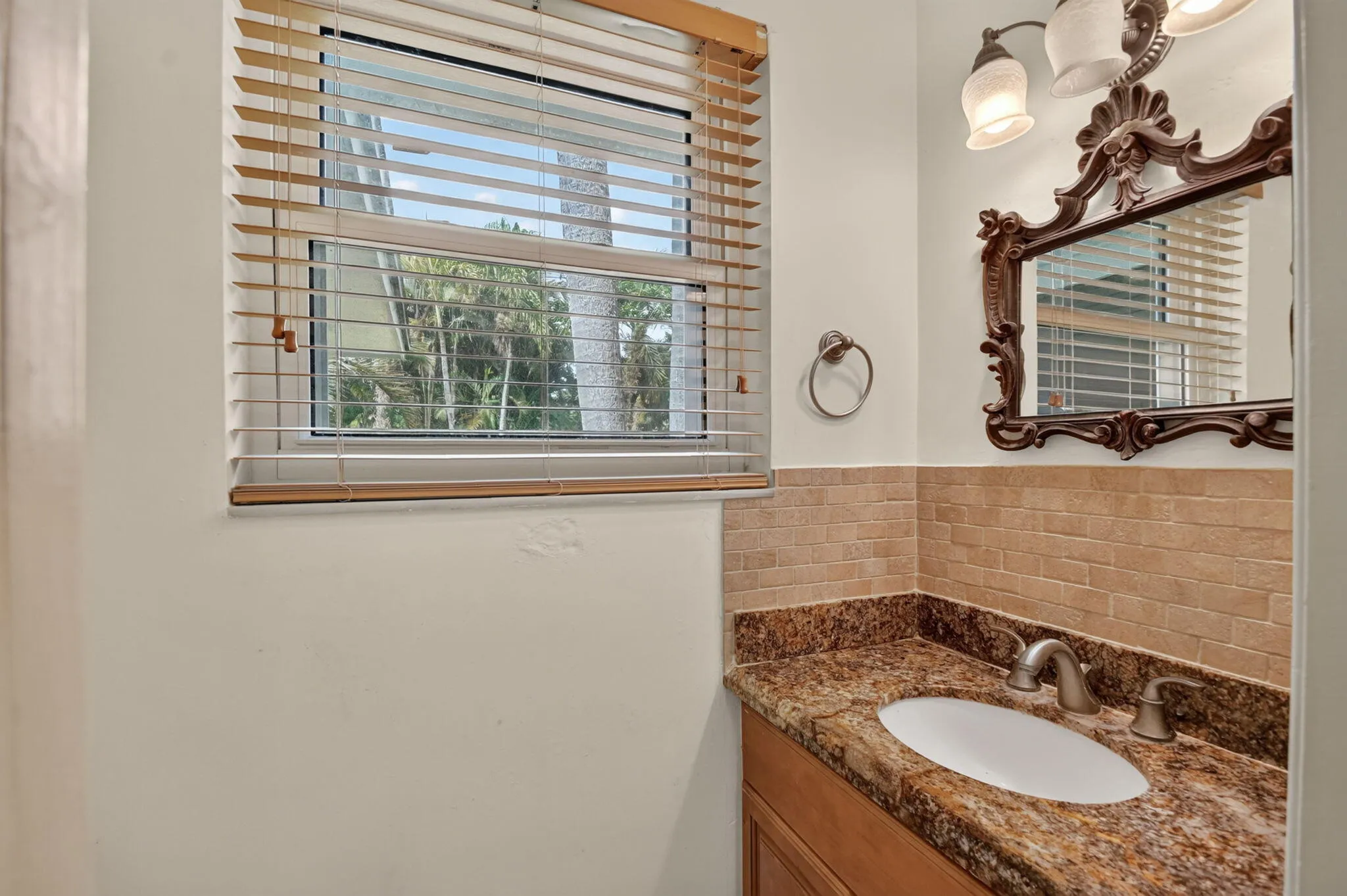Vanity with granite countertop, integrated sink, and brushed nickel faucet