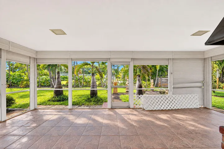 Screened enclosure with tile flooring, white ceiling, and expansive outdoor views
