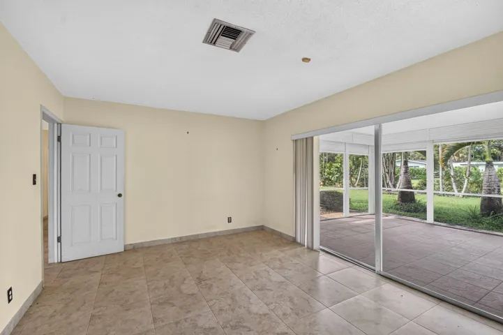 Tiled flooring throughout, neutral wall tones, and direct access to a screened patio