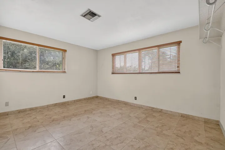 Tile flooring throughout, ample natural light from multiple windows, and a built-in closet organization system