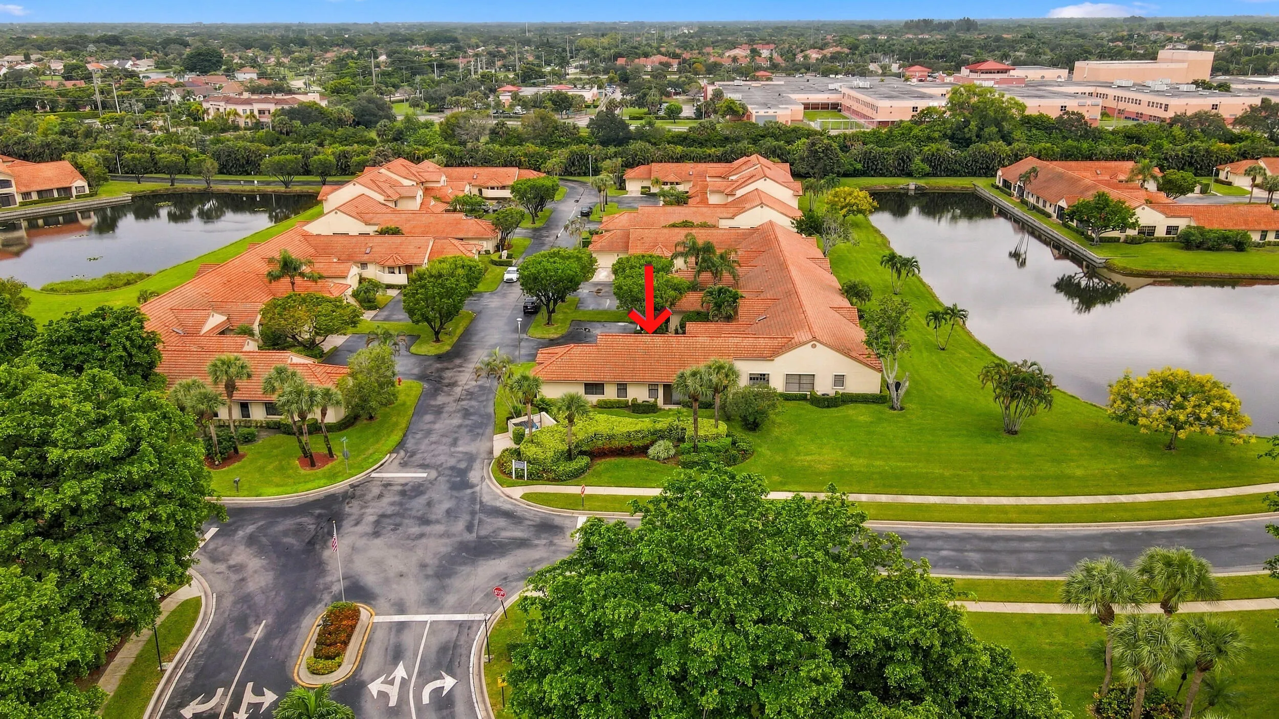 Community with multiple bodies of water, terracotta rooflines, and mature landscaping