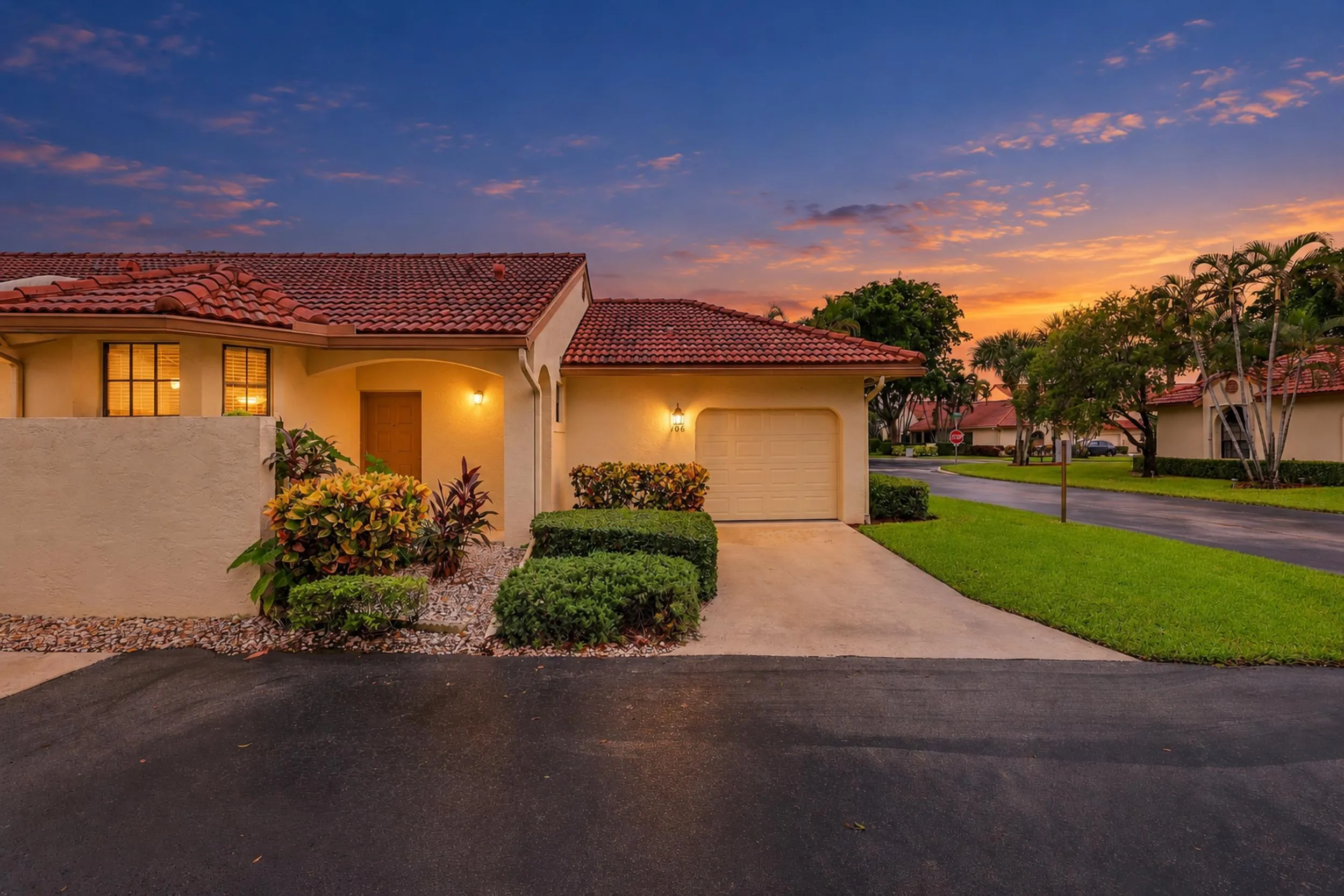 Mediterranean-style exterior with a tile roof, an integrated single-car garage, and a concrete driveway