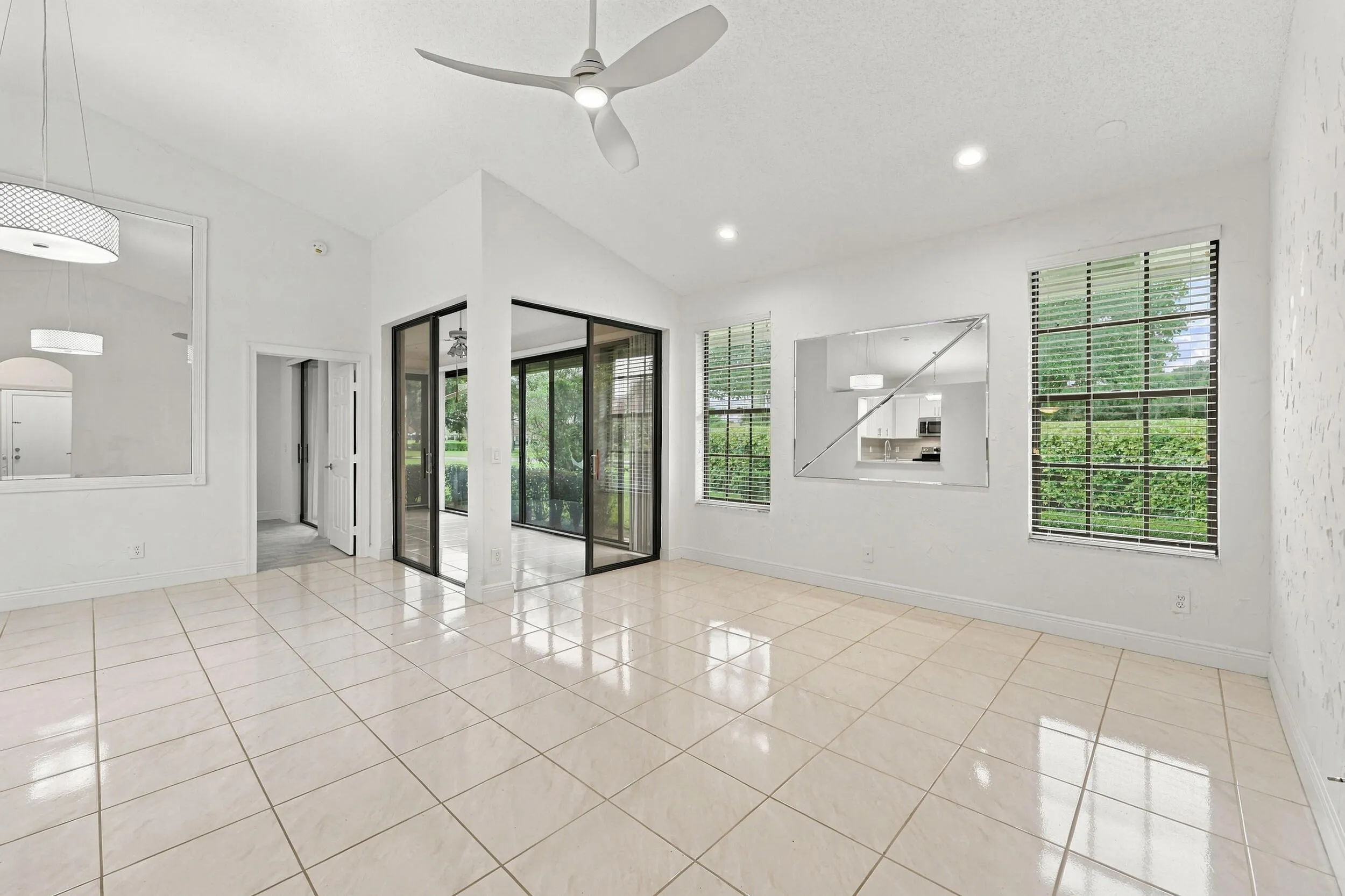 Vaulted ceilings, recessed lighting, ceiling fan, and large windows with blinds