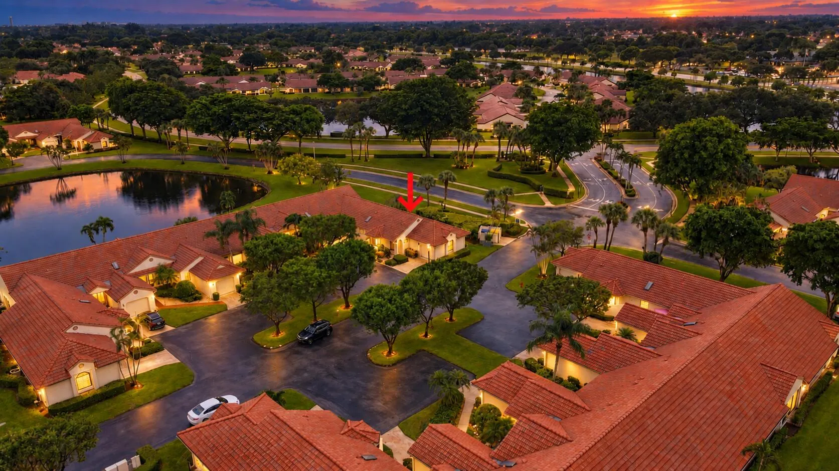 Aerial perspective of a community featuring terracotta-style roofing and lush, mature landscaping